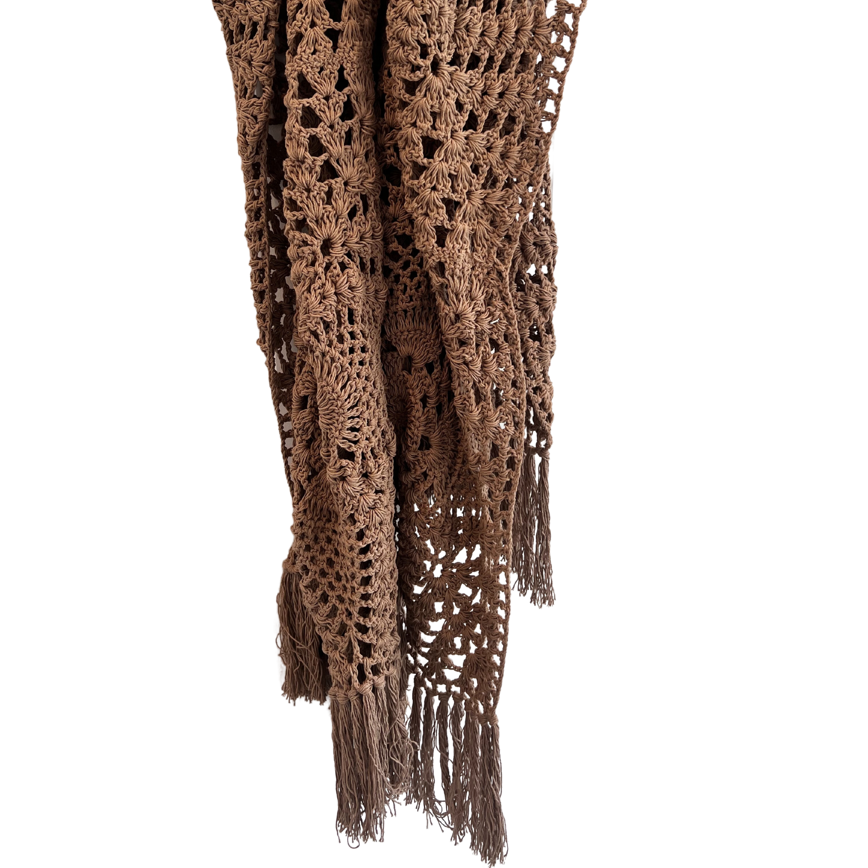 A crocheted cotton throw in an earthy mocha color, draped over a white background, with a fringed end visible.