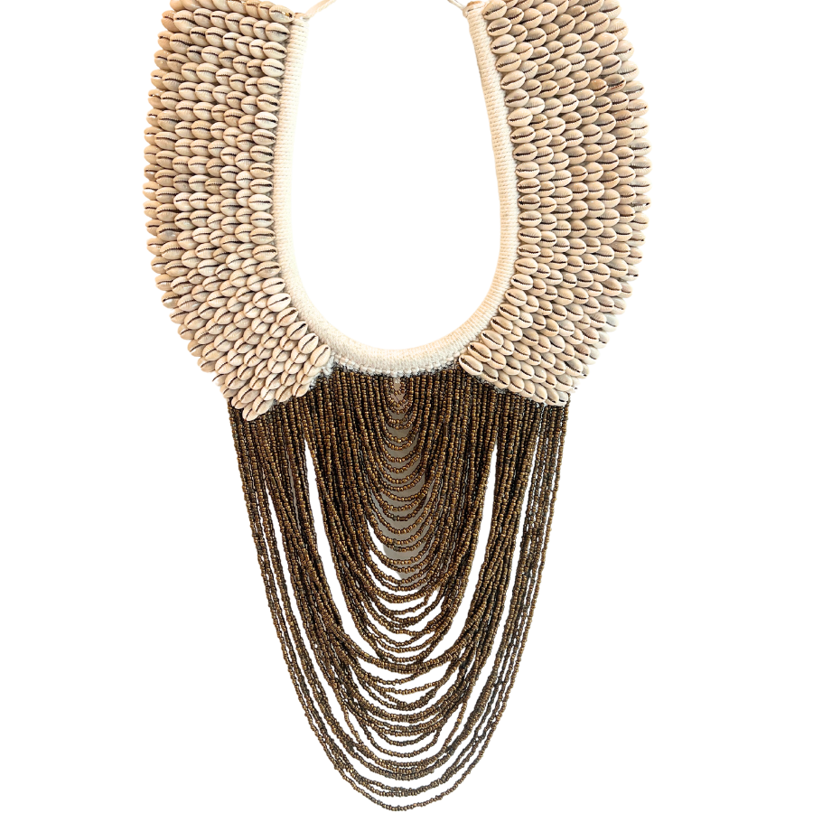 A wall hanging cowrie shell necklace with bronze beading, with a cotton macrame backing, designed to be displayed on a wall.