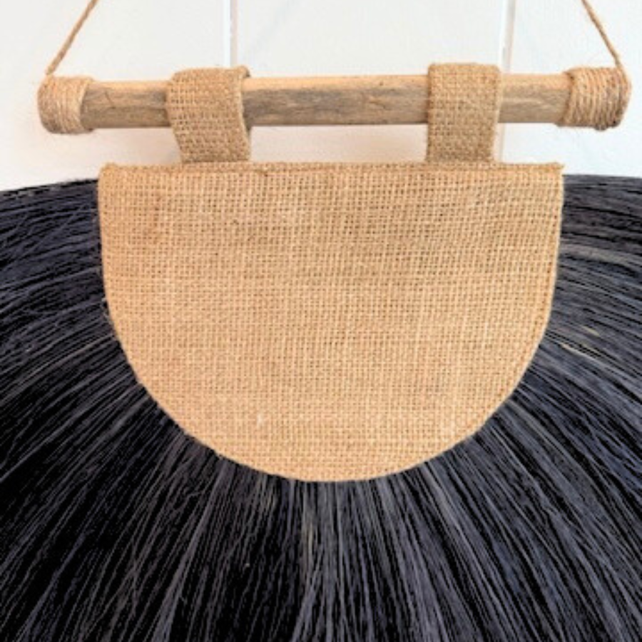 Woven drift wall with black fringe and natural handle.