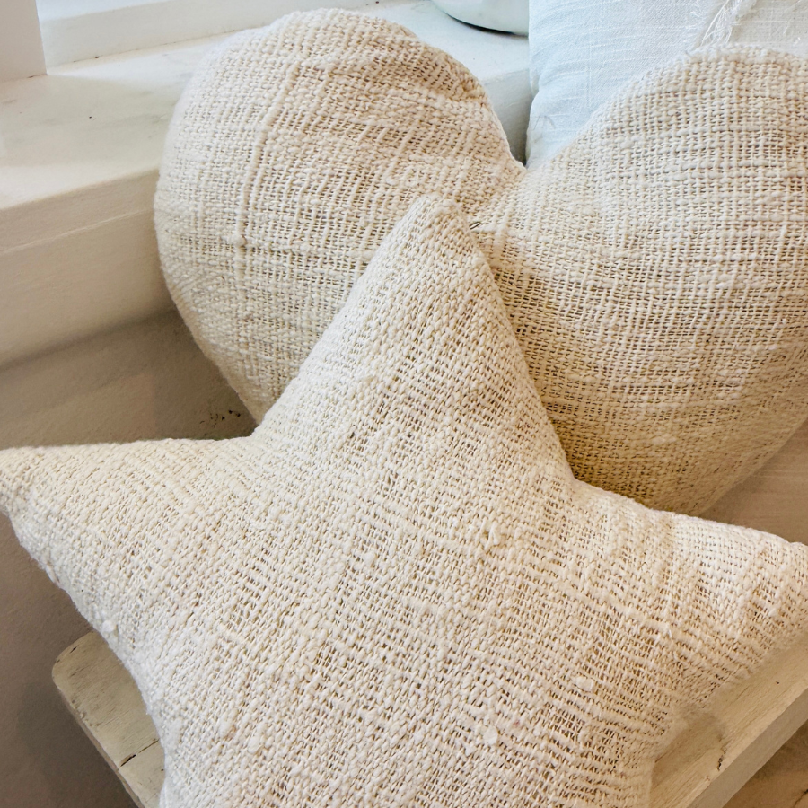 Textured beige cushion on a wooden surface.