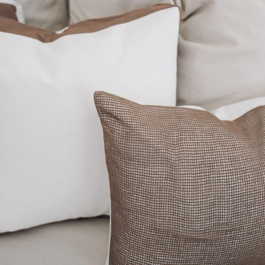 Close-up of decorative cushion on a sofa with neutral colors.