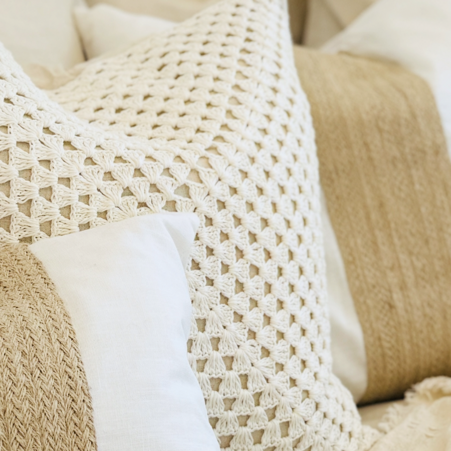 Close-up of a textured beige cushion on a soft surface.