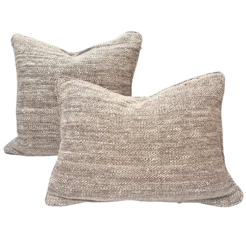 Two arranged square woven throw pillows in a textured beige and taupe fabric.