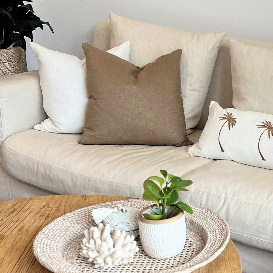 Brown and white cushions with plant decor.