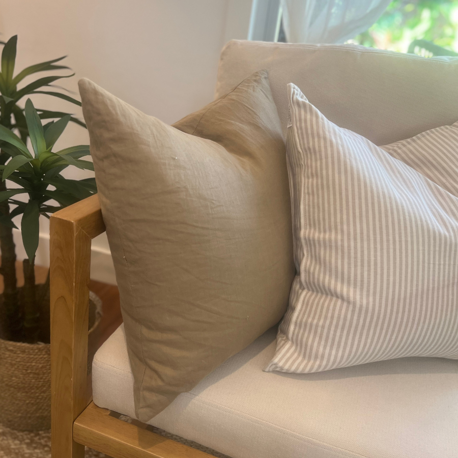 Cushions on a chair with plant decor.