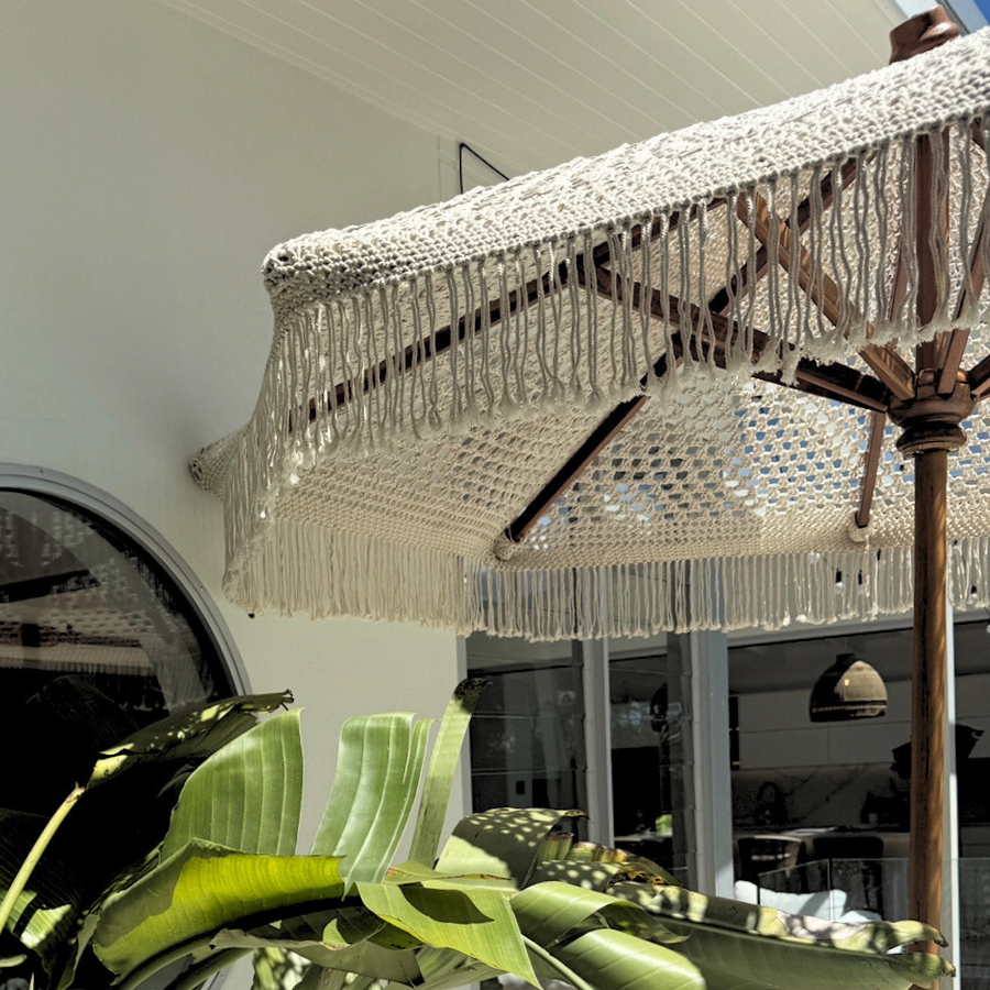 Decorative umbrella with crystal fringe over a plant in an outdoor setting