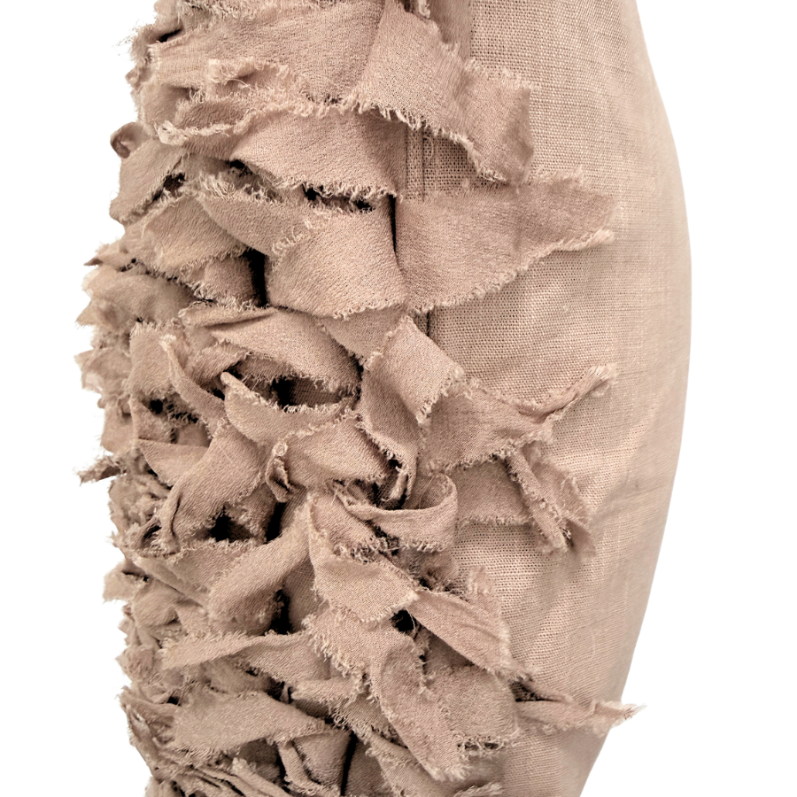 Close-up of a cushion with ruffled layers.