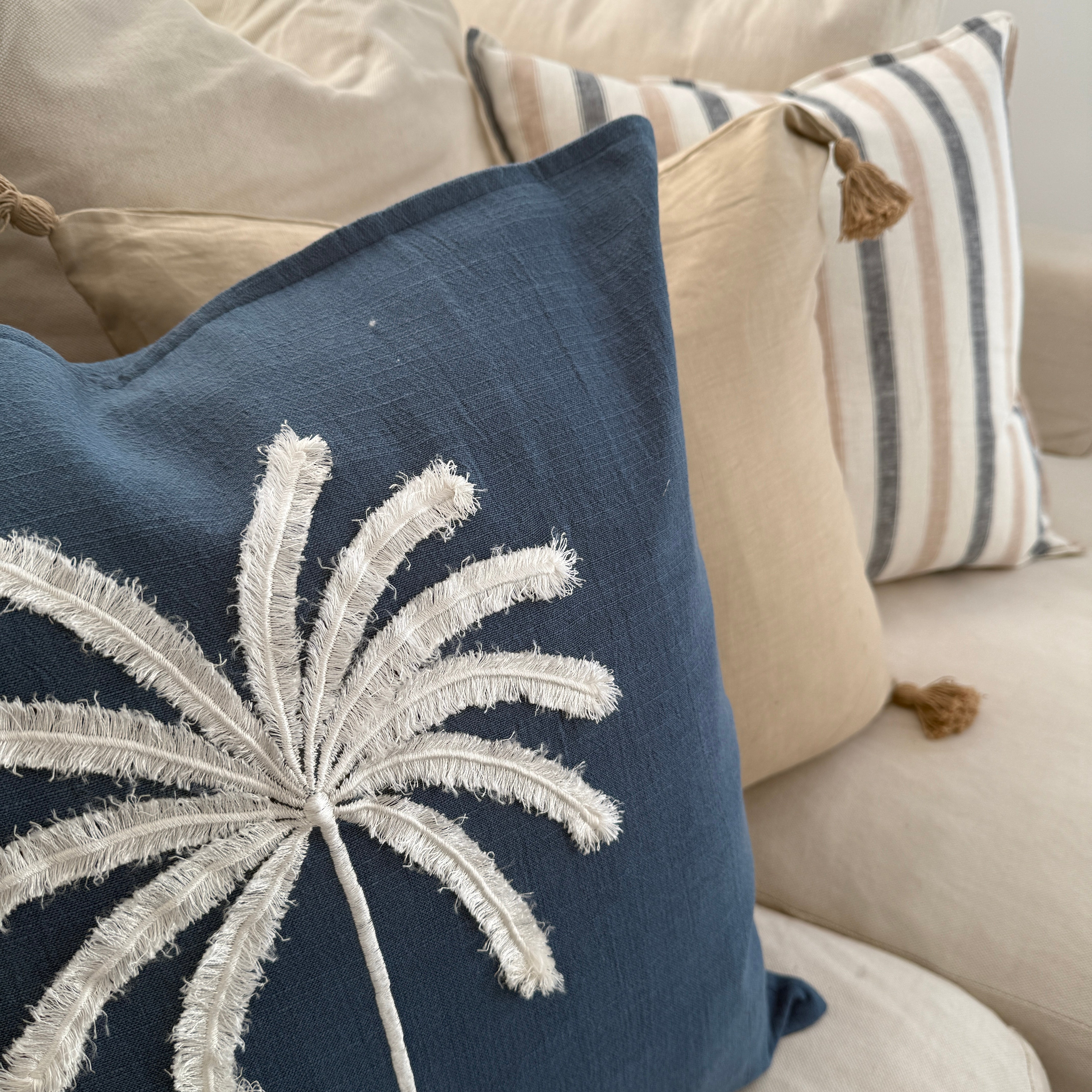 Decorative cushion with a starburst pattern on a couch with other cushion.