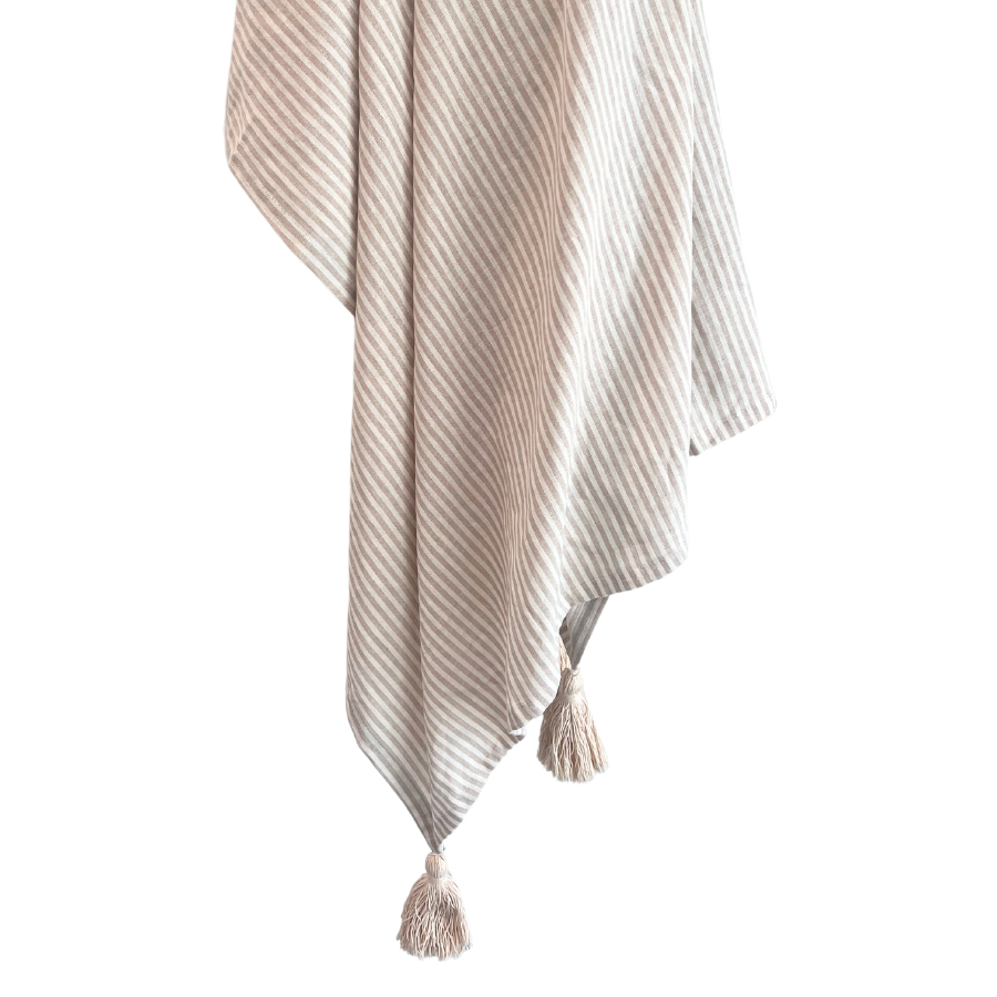 A lightweight tan and ivory striped linen throw with a tassel on one end.