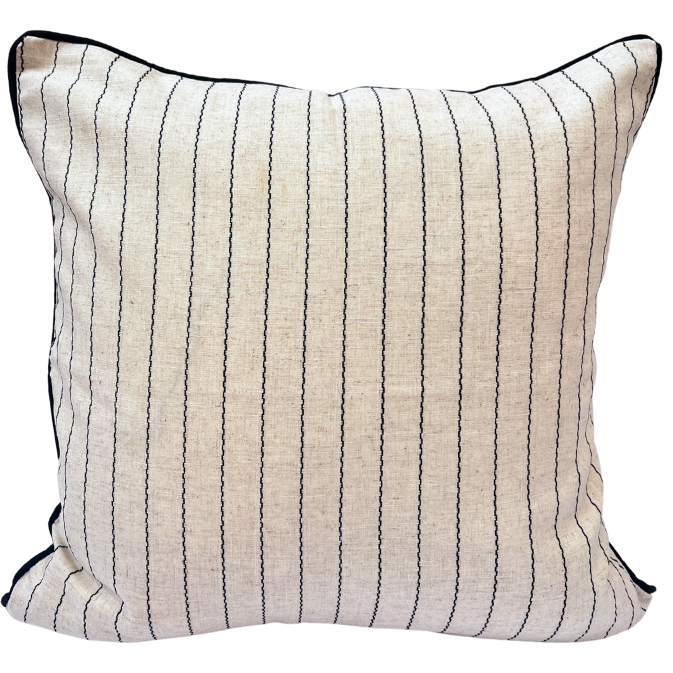 A square-shaped cushion with a natural color fabric and fine cotton stripe details, with a black piped edge and invisible zip.