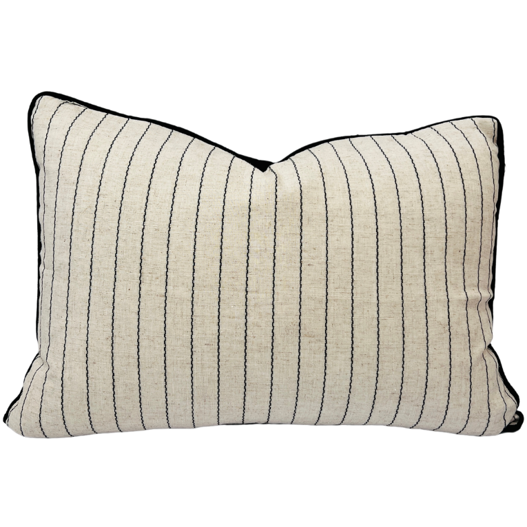 A rectangular cushion with a natural color fabric featuring a fine cotton stripe and 'irregular' black stitching, with a black linen back.