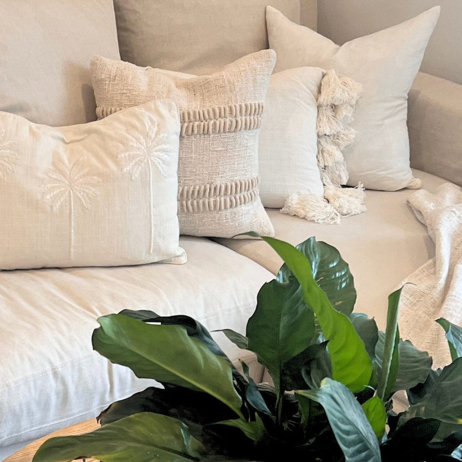 White cushions with plant decor. 